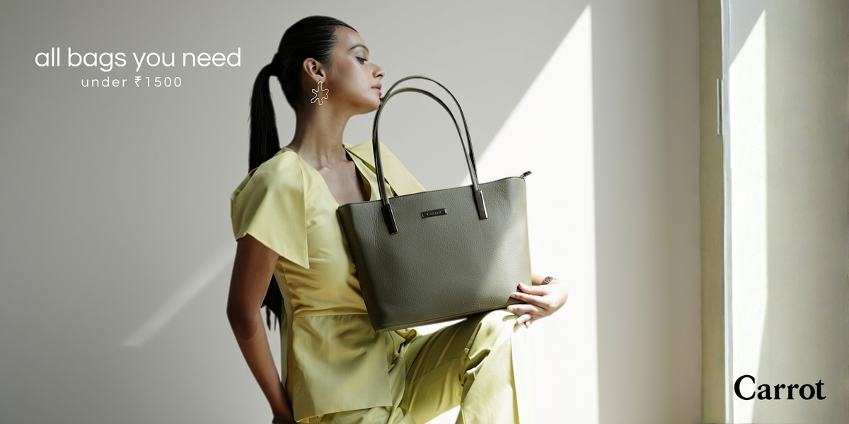 A woman in a yellow outfit holds a large taupe-gray tote bag with black handles, posed in a brightly lit room with strong sunlight and shadows. Text on the left reads 'all bags you need under ₥1500' and the brand name 'Carrot' appears in the bottom right corner.